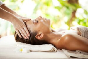 Young woman enjoying during head massage at tropical spa resort.